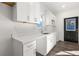 Updated kitchen featuring white cabinets and quartz countertops, with stainless steel sink, faucet, and an exterior door at 1088 Wedgewood Nw Dr, Atlanta, GA 30318