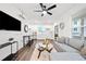 Bright, open-concept living room featuring a comfortable grey sofa, TV, and sleek ceiling fan at 1088 Wedgewood Nw Dr, Atlanta, GA 30318