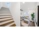 Open-concept living room with wood stairs, a gray sectional, a ceiling fan, and luxury vinyl plank flooring at 1088 Wedgewood Nw Dr, Atlanta, GA 30318