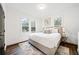 Main bedroom features a gray bed, luxury vinyl plank flooring, and natural light from three windows at 1088 Wedgewood Nw Dr, Atlanta, GA 30318