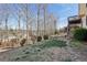 Landscaped backyard featuring a gentle slope, mature trees, and a wooden fence at 70 Wentworth Ln, Villa Rica, GA 30180