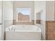 Bright bathroom featuring a white soaking tub beneath a sunny window at 70 Wentworth Ln, Villa Rica, GA 30180