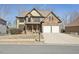 Charming two-story home with a stone and yellow siding exterior and a two-car garage at 70 Wentworth Ln, Villa Rica, GA 30180