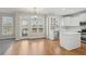 Open concept kitchen and dining area with stainless steel appliances, white cabinets, hardwood floors, island, and natural light at 70 Wentworth Ln, Villa Rica, GA 30180