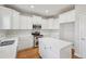 Updated kitchen with stainless steel appliances, white cabinets, quartz countertops, island, and hardwood floors at 70 Wentworth Ln, Villa Rica, GA 30180