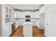 Modern kitchen with white cabinetry, stainless steel appliances, an island, quartz countertops, and hardwood flooring at 70 Wentworth Ln, Villa Rica, GA 30180