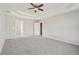 Spacious main bedroom with a tray ceiling, carpet, and doors to bathroom/closet at 70 Wentworth Ln, Villa Rica, GA 30180
