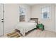 Well-lit bedroom with a cozy bed, neutral walls, two windows, and light tile flooring at 942 Byron Sw Dr, Atlanta, GA 30310