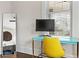 This bedroom features a bright yellow chair and a modern blue desk next to a sunny window at 942 Byron Sw Dr, Atlanta, GA 30310