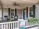 Cozy covered porch featuring comfortable seating, plants, and a view of the Sylvan Hills neighborhood sign at 942 Byron Sw Dr, Atlanta, GA 30310