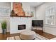 Bright living room features a brick fireplace, hardwood floors, and an ottoman at 942 Byron Sw Dr, Atlanta, GA 30310