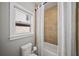 Bathroom with tile surround and tub with shower featuring an open window for natural light at 4916 Kentwood Dr, Marietta, GA 30068