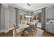 A dining room is furnished with a table, chairs, area rug, modern lighting, and drapes at 4916 Kentwood Dr, Marietta, GA 30068