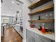 Open concept kitchen with stainless steel appliances, floating shelves, wood floors, and quartz countertops at 4916 Kentwood Dr, Marietta, GA 30068