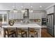 An open concept kitchen featuring an island with seating, pendant lighting, stainless steel appliances, and wood floors at 4916 Kentwood Dr, Marietta, GA 30068
