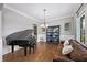 Sophisticated living room with a grand piano, leather sofa, built-in shelving, and elegant chandelier at 4916 Kentwood Dr, Marietta, GA 30068