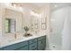 Bathroom featuring double sinks, a shower, a glass door, and gold fixtures at 525 Burlrush Ln # 16, Alpharetta, GA 30009