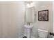 Powder room features pedestal sink, gold mirror, modern vanity, and decorative artwork at 525 Burlrush Ln # 16, Alpharetta, GA 30009