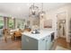 Open kitchen flows into the living room with dining table, large island, and stairs to the second story at 525 Burlrush Ln # 16, Alpharetta, GA 30009
