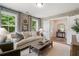 Bright living room featuring neutral tones, large windows with a lush view, and stylish furniture at 525 Burlrush Ln # 16, Alpharetta, GA 30009