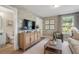 Cozy living room with floral wallpaper, natural light, modern entertainment center, and a connected bathroom at 525 Burlrush Ln # 16, Alpharetta, GA 30009