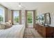 Sunlit main bedroom featuring a ceiling fan, three windows, and wood floors at 525 Burlrush Ln # 16, Alpharetta, GA 30009