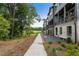 Row of modern townhomes featuring balconies, garages, landscaping, and exterior bench seating at 525 Burlrush Ln # 16, Alpharetta, GA 30009
