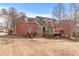 Stately red brick home featuring dormer windows and a wooden deck, set on a sprawling lawn at 2914 Stanway Ave, Douglasville, GA 30135