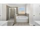 Bathroom featuring a large soaking tub, glass shower and frosted window for added privacy and natural light at 502 Stoneland Pl, Lawrenceville, GA 30046