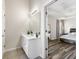 Bright bathroom featuring a modern vanity with white cabinets and a large mirror with an open view to the main bedroom at 502 Stoneland Pl, Lawrenceville, GA 30046