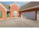 Brick home featuring a garage and a green front door at 502 Stoneland Pl, Lawrenceville, GA 30046