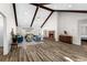 Spacious living room with high ceilings, exposed beams, a brick fireplace, and wood-look flooring at 502 Stoneland Pl, Lawrenceville, GA 30046