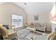 Sun-drenched living room featuring stylish seating and modern decor with a large bright window at 502 Stoneland Pl, Lawrenceville, GA 30046