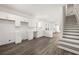 Bright kitchen features all-white cabinetry and stainless steel sink with an open layout into a living area and nearby stairs at 1106B Wedgewood Nw Dr, Atlanta, GA 30318