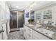 Updated bathroom with a double sink vanity, modern fixtures, and a tiled shower at 3597 Embry Cir, Atlanta, GA 30341