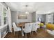 This dining room features a wood table, upholstered chairs, hardwood floors, and stylish light fixture at 3597 Embry Cir, Atlanta, GA 30341
