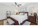 Bright main bedroom with a ceiling fan, king size bed, bench and hardwood floors at 3597 Embry Cir, Atlanta, GA 30341
