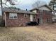 Back exterior view of a two-story brick home with a well-maintained yard and porch at 951 Bingham Ln, Stone Mountain, GA 30083