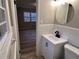Updated bathroom boasts a new vanity with a black faucet, tiled walls, and a round mirror at 951 Bingham Ln, Stone Mountain, GA 30083