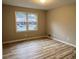 A bright bedroom features wood-look floors and a window with views of the front yard at 951 Bingham Ln, Stone Mountain, GA 30083