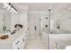 Bright bathroom featuring a glass shower, double vanity, and elegant marble tile at 1629 Phillips Rd, Lithonia, GA 30058