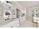 Bright bathroom featuring dual sinks, a soaking tub, and a glass shower at 1629 Phillips Rd, Lithonia, GA 30058