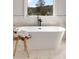 Modern white soaking tub complemented by a black faucet and a scenic window view at 1629 Phillips Rd, Lithonia, GA 30058