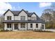 Stunning two-story home featuring white painted brick, a dark roof, and covered front porch at 1629 Phillips Rd, Lithonia, GA 30058