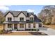 A two-story house with a modern farmhouse design, lush landscaping, and a well-manicured lawn at 1629 Phillips Rd, Lithonia, GA 30058
