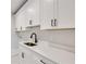 Bright laundry room offers ample storage space with shaker cabinets and modern fixtures at 1629 Phillips Rd, Lithonia, GA 30058