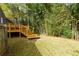 A lush backyard with a deck and stairs leading to the grass, surrounded by bamboo and greenery at 6596 Wright Rd, Atlanta, GA 30328