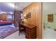 View of bedroom space with wood walls, a brick partition, desk, and doorway to bathroom at 6596 Wright Rd, Atlanta, GA 30328