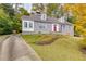 Charming gray home featuring a red door, dormer windows, and well-maintained front yard at 6596 Wright Rd, Atlanta, GA 30328