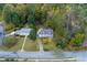 A quaint home with a red door sits amid trees and manicured lawns along a quiet street at 6596 Wright Rd, Atlanta, GA 30328